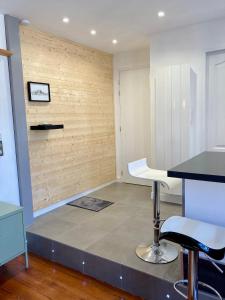 Le Nivolet, cosy appartement في شامبيري: غرفة مع منضدة ومقعد بار