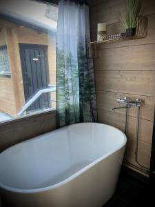 una vasca bianca in un bagno con finestra di WALD Villas - Aavasaksa, Lapland ad Aavasaksa
