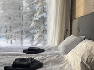 a bed with two towels on it in front of a window at WALD Villas - Aavasaksa, Lapland in Aavasaksa