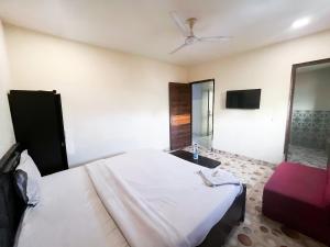 una camera con letto bianco e ventilatore a soffitto di Roomshala 161 Hotel Three Kings a Nuova Delhi