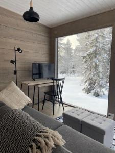 1 dormitorio con cama, escritorio y ventana en WALD Villas - Aavasaksa, Lapland, en Aavasaksa
