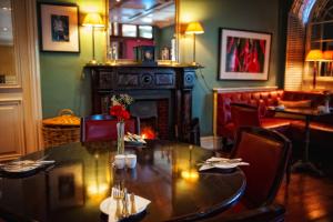 a dining room with a table and a fireplace at Step House Hotel in Borris