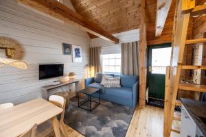 a living room with a blue couch and a television at Västervik Resort in Västervik