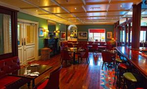 a restaurant with tables and chairs and a bar at Step House Hotel in Borris