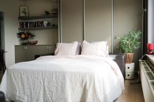 - une chambre avec un lit et une couette blanche dans l'établissement holiday vibes! penthouse-studio near beach, à Ostende