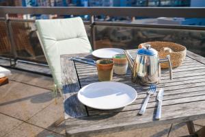 - une table en bois avec des assiettes et des ustensiles dans l'établissement holiday vibes! penthouse-studio near beach, à Ostende