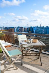 une table et des chaises sur le toit d'un bâtiment dans l'établissement holiday vibes! penthouse-studio near beach, à Ostende