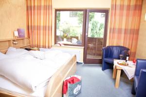 a hotel room with a bed and chairs and a window at Bio-Hotel Upländer Hof in Willingen