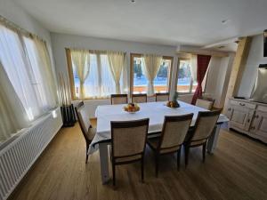 a dining room with a white table and chairs at Chalet Familial Sublime in Crans-Montana