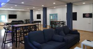 - un salon avec un canapé, des tables et des chaises dans l'établissement Hostel Spinut, à Split