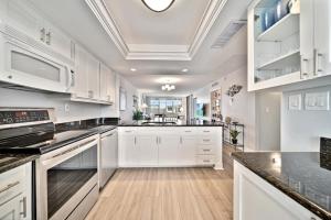 a kitchen with white cabinets and a ceiling at Loggerhead Cay #324 in Sanibel