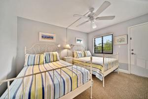 Un dormitorio con dos camas y un ventilador de techo. en Loggerhead Cay #322, en Sanibel