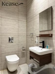 ein Badezimmer mit einem Waschbecken, einem WC und einem Spiegel in der Unterkunft Kease Yasmin F-1 Lusso Hejaz GX41 in Riad