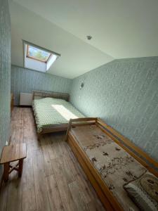 sypialnia z 2 łóżkami i małym oknem w obiekcie Dimanti w mieście Ragaciems