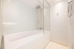 a white bathroom with a glass shower stall at Hotel L'Ermitage in Tallinn