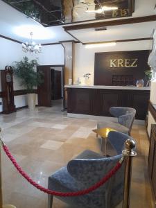 a lobby with a barbershop with a chain and chairs at Hotel KREZ in Qyzylorda