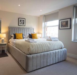 a large bed in a bedroom with a large window at Kensington High Street One Bed in London