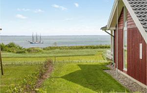 Casa roja con vistas al océano y a un barco en Beautiful Home In Sydals With 3 Bedrooms, Sauna And Wifi, en Skovby