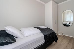- une chambre blanche avec un lit et un miroir dans l'établissement Framnesvegur - Two Bedroom Central Apartment, à Reykjavik