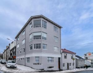 un bâtiment gris avec une voiture garée devant lui dans l'établissement Framnesvegur - Two Bedroom Central Apartment, à Reykjavik