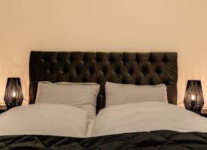 1 cama con cabecero negro y 2 almohadas blancas en Ranargata - Central One Bedroom Apartment, en Reikiavik