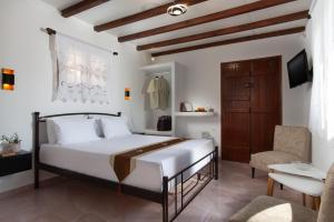 a bedroom with a large white bed and a chair at Deja Dream Homes in Schinopi