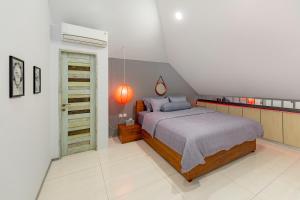 a bedroom with a bed and an orange lamp at Beautiful Penthouse w/ incredible views, pool, & cinema room! in Canggu +67 photos