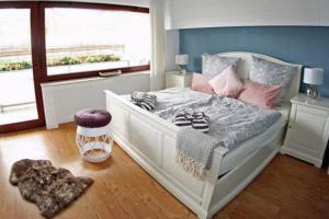 ein Schlafzimmer mit einem großen weißen Bett mit rosa Kissen in der Unterkunft Ferienhaus Mosel Cottage in Piesport in Piesport