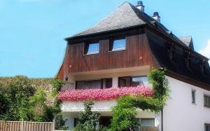 ein Haus mit rosa Blumen auf der Seite in der Unterkunft Ferienhaus Mosel Cottage in Piesport in Piesport