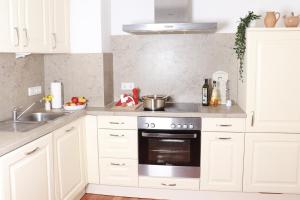 a kitchen with white cabinets and a stove at Mosel Cottage in Piesport in Piesport