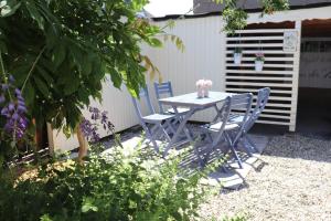 einen Tisch und Stühle in einem Garten mit Blumen darauf in der Unterkunft Ferienhaus Mosel Cottage in Piesport in Piesport