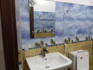 łazienka z umywalką, lustrem i palmami w obiekcie Forest Paddy Homestay w mieście Ella