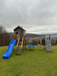 une aire de jeux avec des toboggans et une structure de jeux dans l'établissement Domki Wincentego, à Ustrzyki Dolne