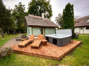 una terraza con bañera de hidromasaje y sillas y una casa en Private House, 