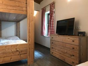 a bedroom with a bed and a television on a dresser at Almhütte Hannah in Sonnenalpe Nassfeld