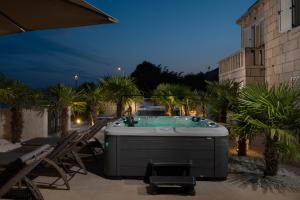 a jacuzzi tub sitting on a patio at night at Jakuzzi Vila Suartini Orebić in Orebić