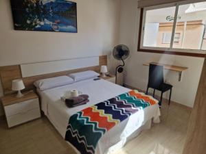 a bedroom with a bed and a desk and a window at Habitación matrimonial privada con areas compartidas in Las Lagunas