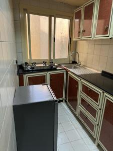 a kitchen with a sink and a refrigerator at Fully Furnished Studio Appartment next to Sharaf DG metro Station in Dubai