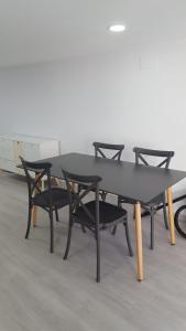 una mesa con cuatro sillas alrededor en una habitación en Casa Estife - Vivienda a pie de playa en Bares en Bares