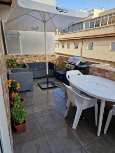 a patio with an umbrella and a table and chairs at Habitación matrimonial privada con areas compartidas in Las Lagunas