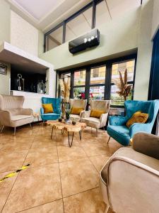 sala de estar con sillas azules y mesa en Mc Queen Rooms & Apartments, en Atenas