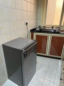 uma cozinha com um pequeno frigorífico. em Fully Furnished Studio Appartment next to Sharaf DG metro Station em Dubai