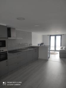 una cocina con electrodomésticos blancos y un sofá en una habitación en Casa Estife - Vivienda a pie de playa en Bares en Bares