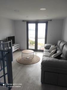 sala de estar con sofá y mesa en Casa Estife - Vivienda a pie de playa en Bares en Bares