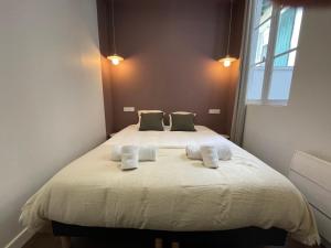 een slaapkamer met een groot bed met 2 kussens bij Élégant et lumineux appartement à proximité de tous les lieux d'intérêt in Biarritz