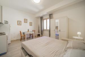- une chambre blanche avec un lit et une table dans l'établissement A Casa di Coco - Goelba, à Portoferraio