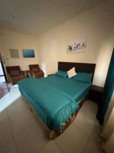 1 dormitorio con 1 cama con edredón verde en Fully Furnished Studio Appartment next to Sharaf DG metro Station en Dubái