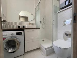 een badkamer met een wasmachine en een toilet bij Élégant et lumineux appartement à proximité de tous les lieux d'intérêt in Biarritz