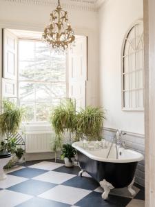 La salle de bains est pourvue d'une baignoire et de plantes en pot. dans l'établissement Wilde Cedar, à Binfield