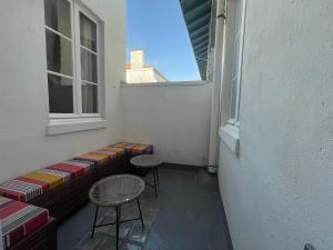 een klein balkon met 2 krukken en een raam bij Élégant et lumineux appartement à proximité de tous les lieux d'intérêt in Biarritz